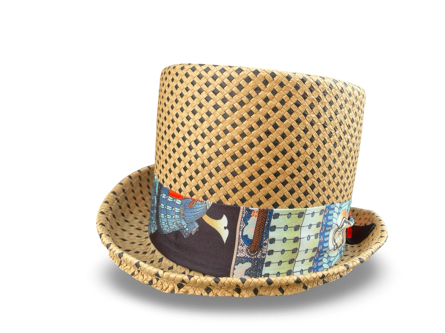 Woven polka dot straw top hat with a colorful twilly on a white background