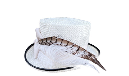 White woven hat with black piping and feathers on a white background