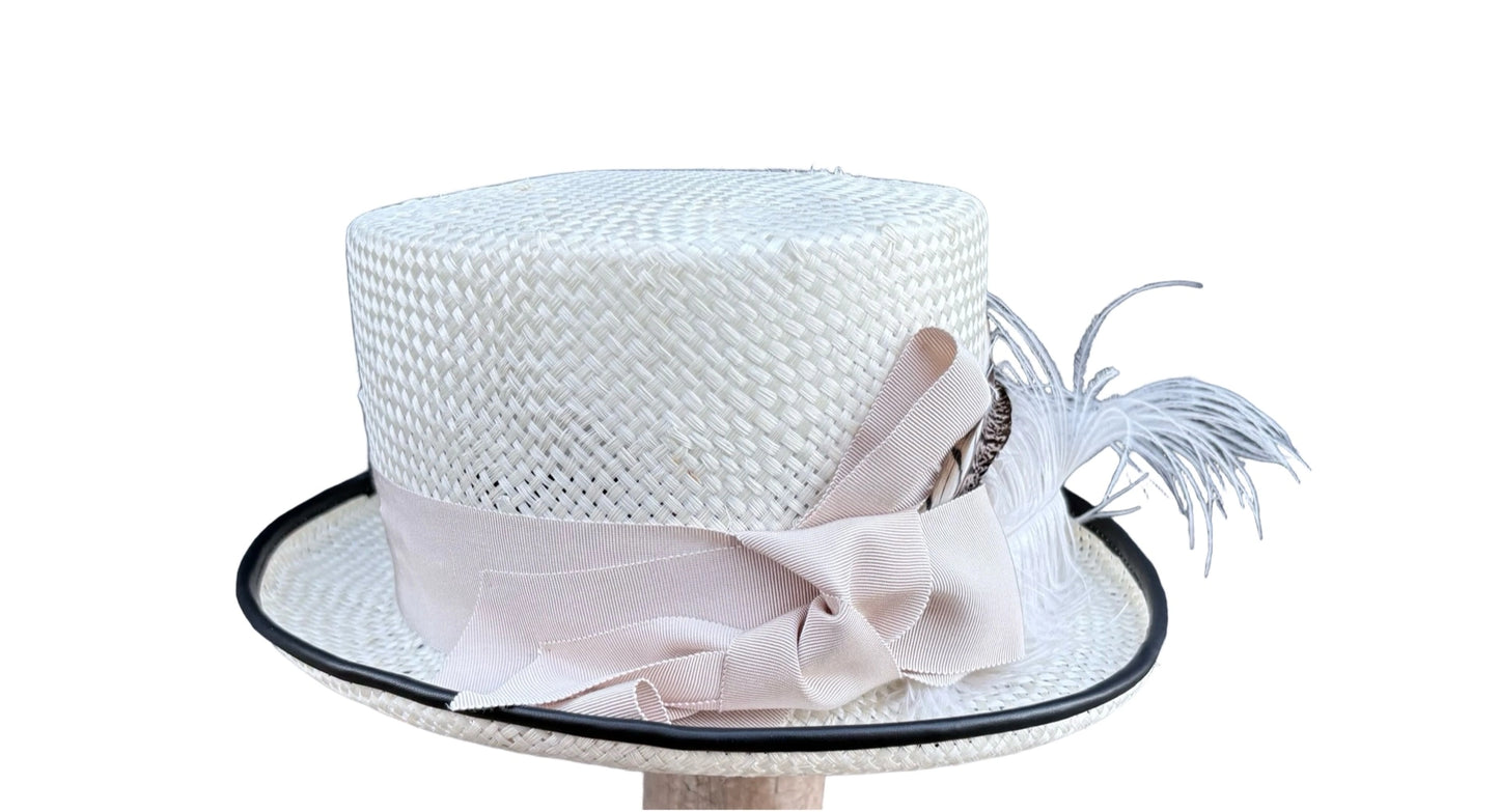 White woven hat with a decorative bow and feather on a white background, right view