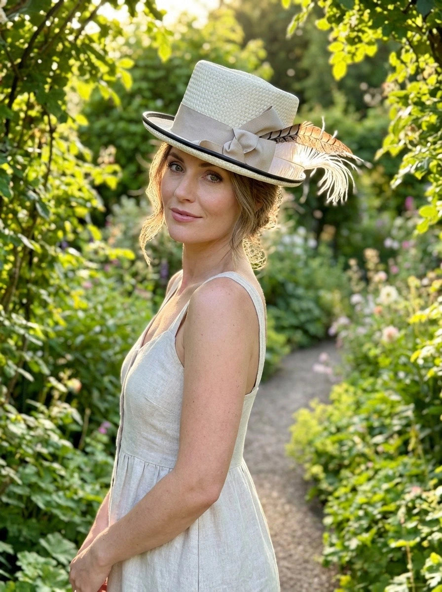 Woman wearing a decorative coachman hat in a garden setting