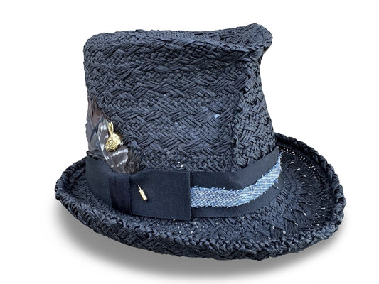 Black crochet straw hat with decorative band and feather on a white background