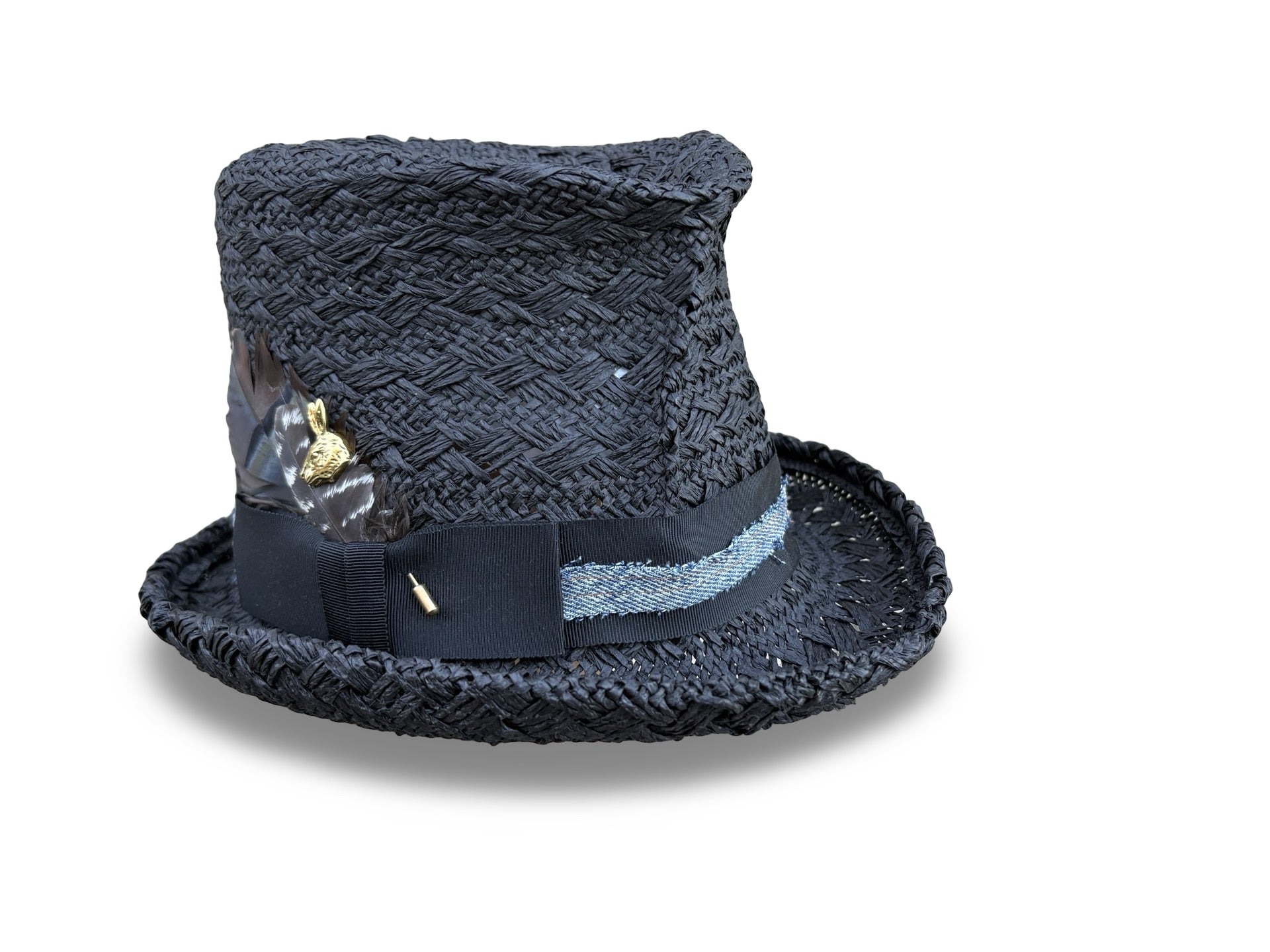 Black croche straw top hat with decorative ribbon and gold stickpin on a white background