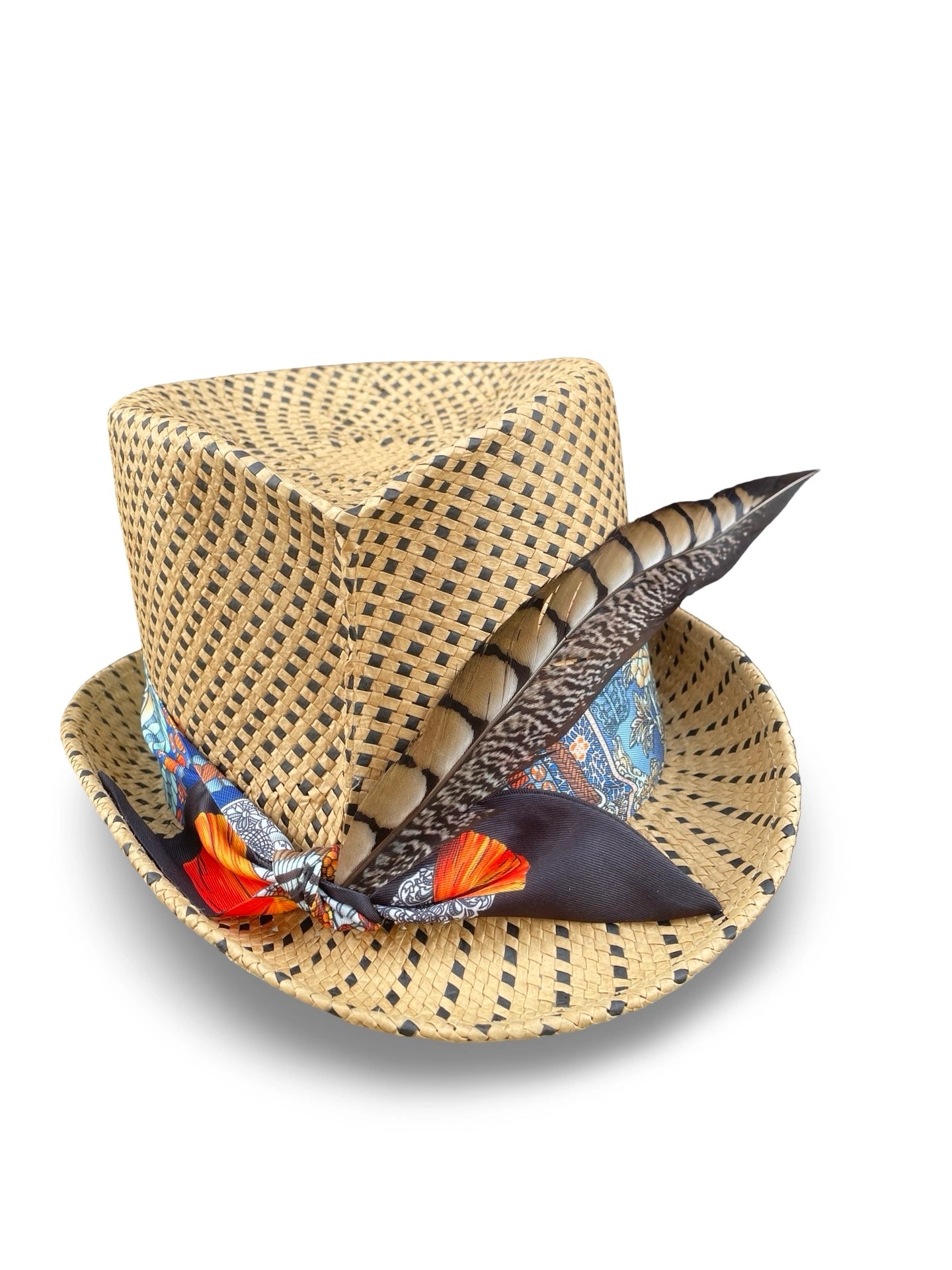 Woven straw hat with decorative feather and twilly on a white background
