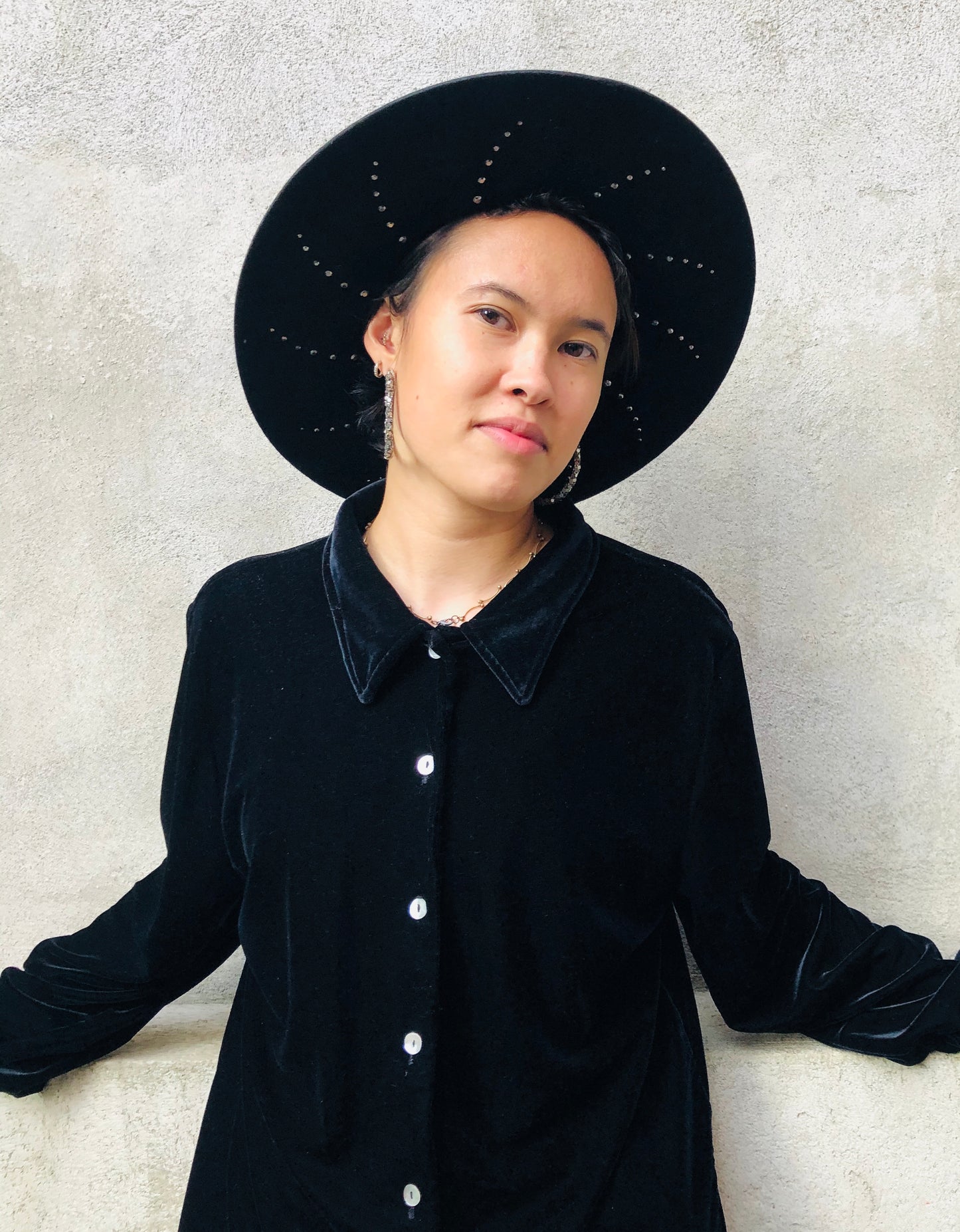 Black wool felt fedora with suede cord trim. Under-brim features a unique halo stud design
