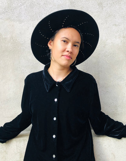 Black wool felt fedora with suede cord trim. Under-brim features a unique halo stud design