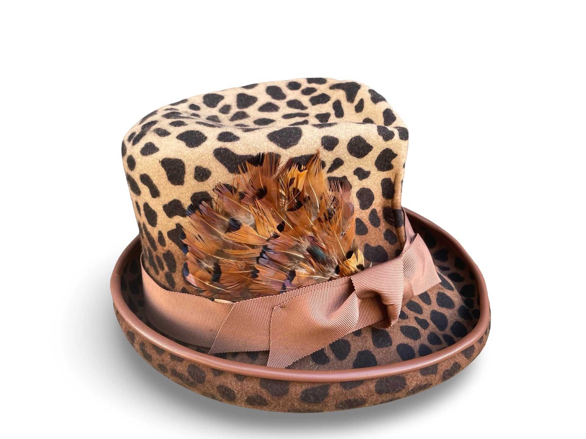 Leopard print hat with feathers and a bow on a white background