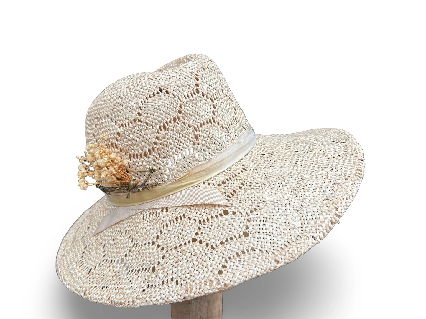 Beige straw hat with a decorative band and flower on a white background