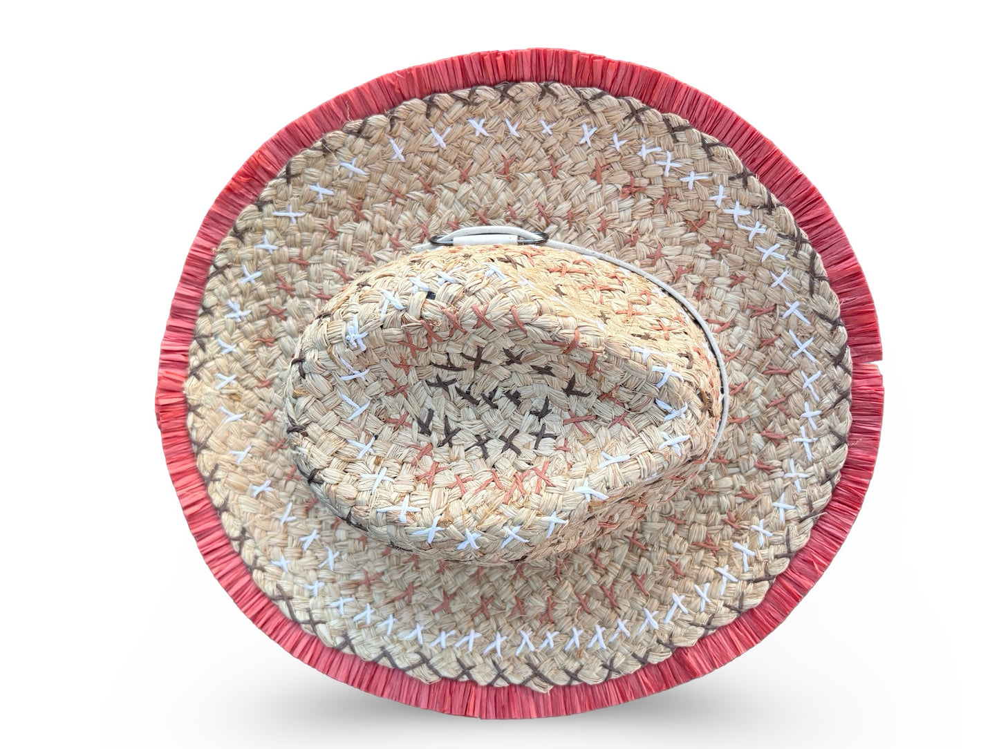 A woven straw cowboy hat viewed from directly above, featuring a natural beige straw body with white and black stitched details and a prominent red fringed border.