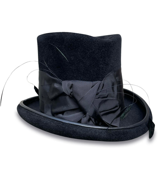 A luxurious black fur felt top hat, called the "Ringmaster," with a tall crown and classic brim, adorned with a wide black ribbon and elegant coque feathers, finished with signature lambskin piping. 
