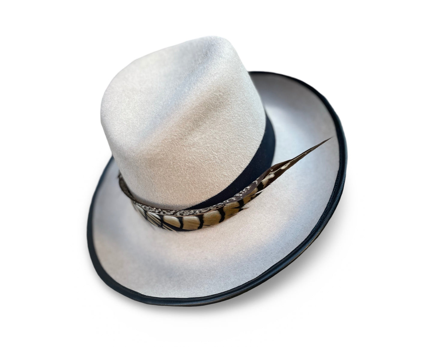Alabaster Fedora trimmed with black grosgrain and pheasant tail. Brim is piped with black lamb skin