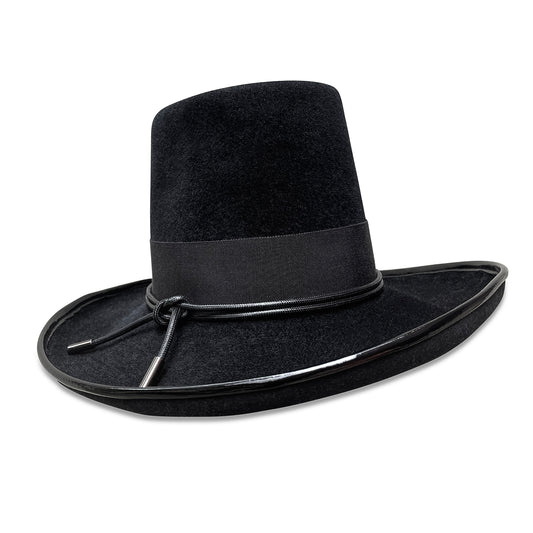 A sophisticated black top hat with a tall, fez-style crown and an upswept brim outlined with black patent leather piping. The hat is adorned with a black matte grosgrain band topped with a shiny black cord. It's designed and made-to-order by Cha Cha's House of Ill Repute in New York City.
