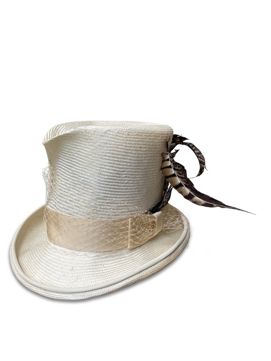 White Wing Dove Madhatter white top hat from woman-owned millinery Cha Cha's House of Ill Repute. A white top hat made of ivory parisisol straw with a decorative band featuring feathers, veiling, and vintage grosgrain ribbon. The brim is detailed with lambskin piping for added luxury and durability. 