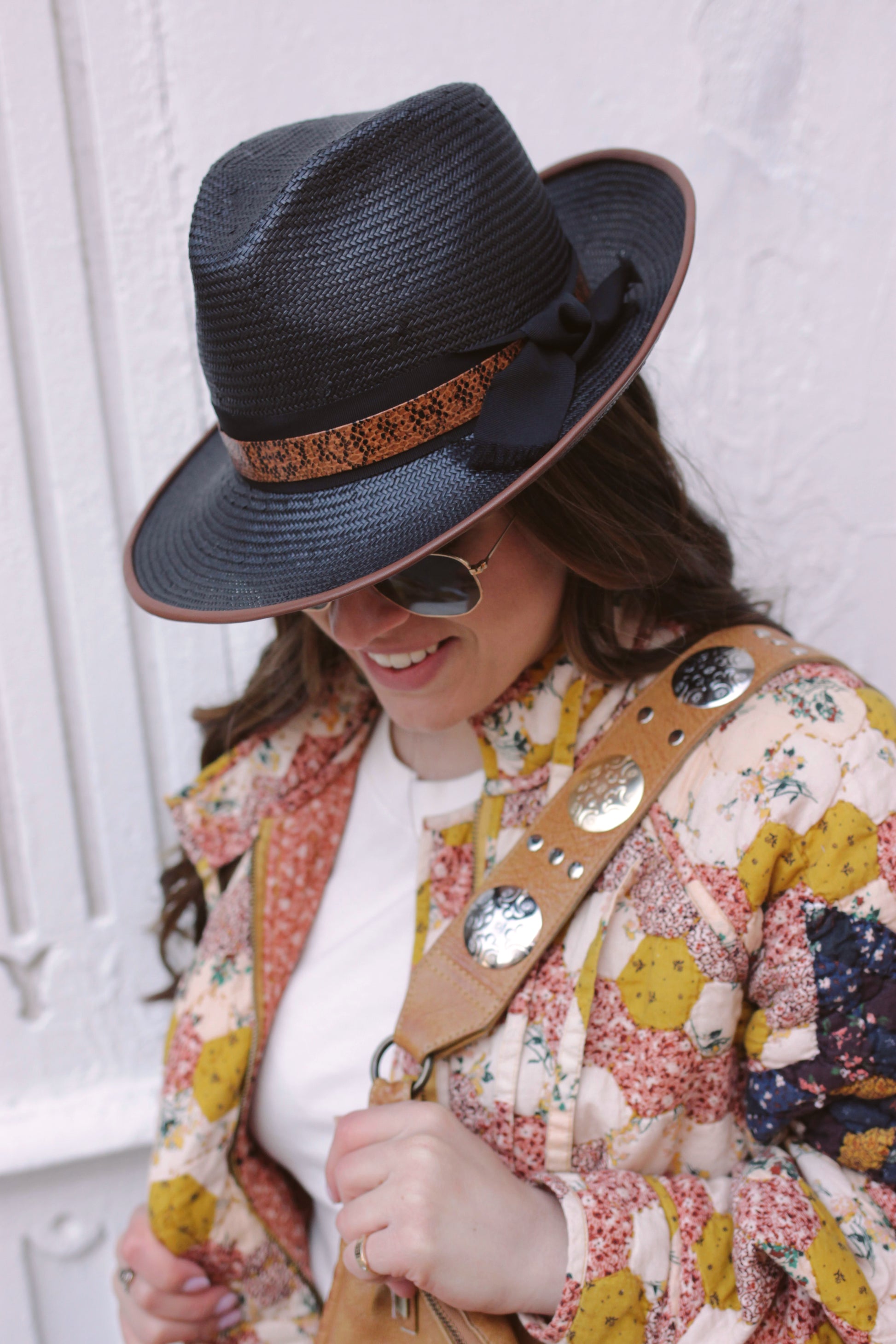 Black straw fedora with chocolate leather piping. Black ribbon trim overlaid with lizard layer. Center dent crown with three inch brim. Shown on model. 
