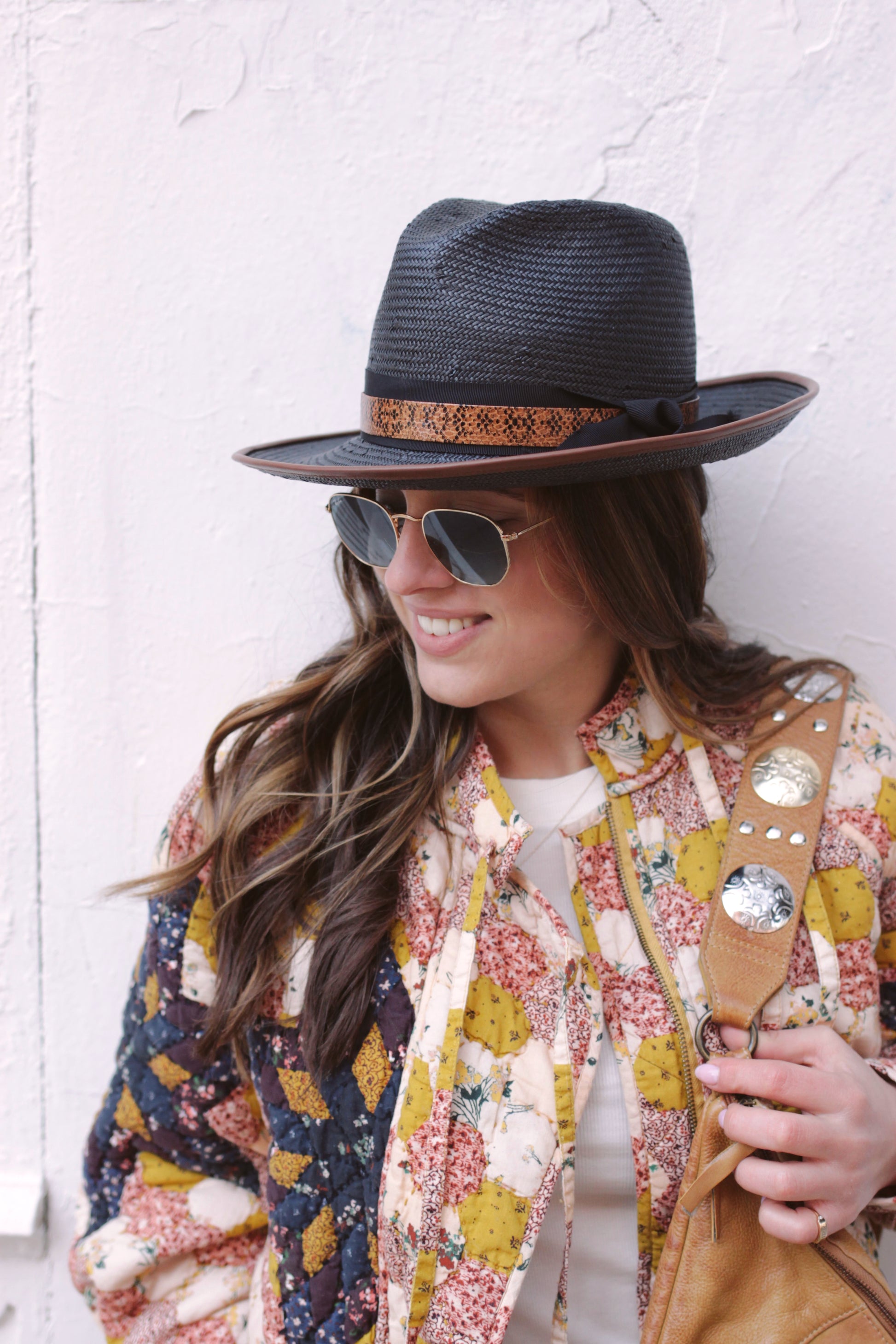 Black straw fedora with chocolate leather piping. Black ribbon trim overlaid with lizard layer. Center dent crown with three inch brim. Show on model. 