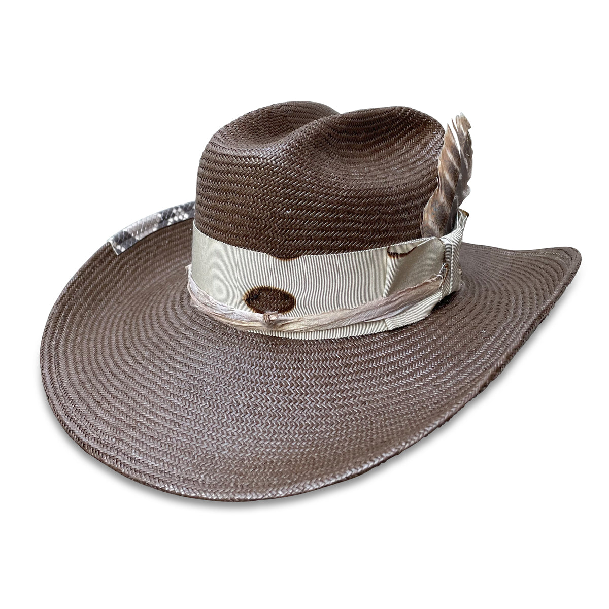 Artisanal brown straw cowboy hat with elegant ribbon layers, a snakeskin touch, and a feather, by Cha Cha's  House of Ill Repute in New York